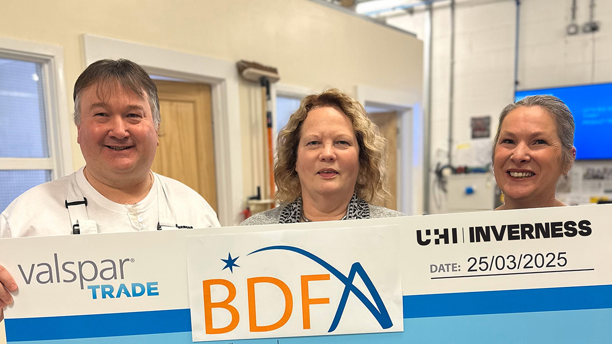 one man and two women holding up a charity banner