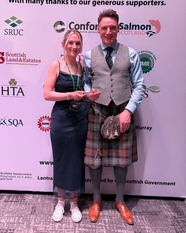 Ailie Macleod holding ALBAS award with Lecturer David Olds at the awards ceremony