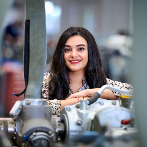 A person leaning on a plane propeller motor A person leaning on a plane propeller motor