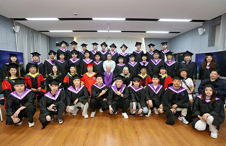 A group of university students in their formal graduation robes inside a university building