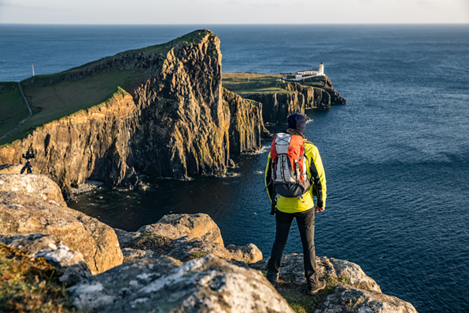 A person standing on the edge of a cliff overlooking Neist Point A person standing on the edge of a cliff overlooking Neist Point
