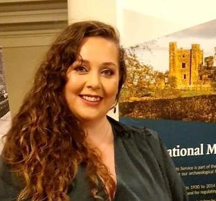 Woman smiling at a camera with a pop-up banner showing a ruined castle behind her.  Woman smiling at a camera with a pop-up banner showing a ruined castle behind her.