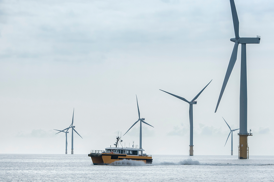 Boat sailing past an offshore windfarm Boat sailing past an offshore windfarm