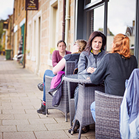 People sitting in an outside Cafe area People sitting in an outside Cafe area