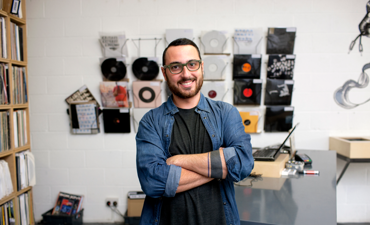 Man standing in front of music records Man standing in front of music records